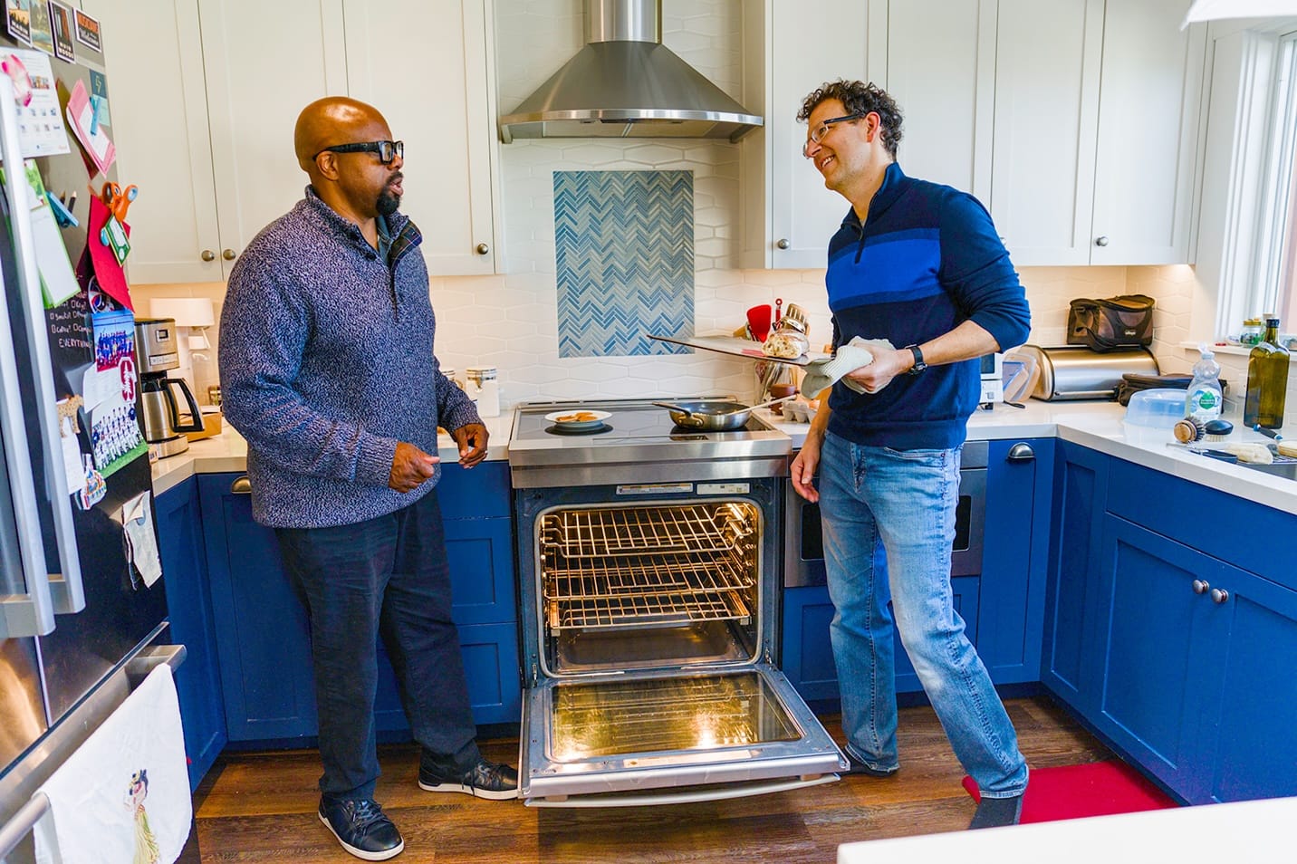 Two men standing in front of an induction stove